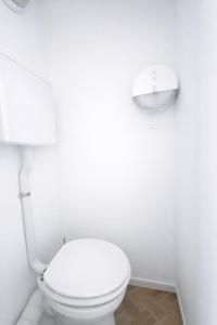 ein weißes Badezimmer mit Toilette und Wandleuchte in der Unterkunft The Val Hotel in Châlus + 1 Foto
