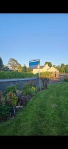 a field of grass with a building in the background at Crossriver B&B in Oughterard