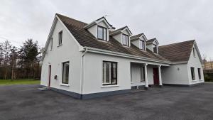 a large white house with a lot of windows at Crossriver B&B in Oughterard