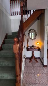 a staircase with a table and a mirror in a room at Crossriver B&B in Oughterard