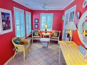 a living room with red walls and a table and chairs at Just Peachy in Myrtle Beach
