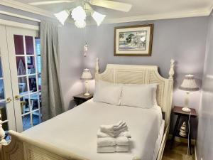 a bedroom with a white bed with towels on it at Just Peachy in Myrtle Beach