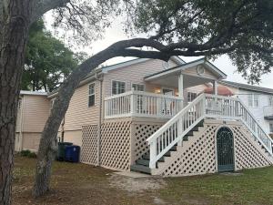 a large white house with a porch and stairs at Just Peachy in Myrtle Beach