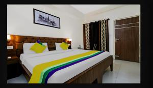 a bed with a rainbow blanket on it in a room at Hotel Starwood Near Airport Road Sector 78 Mohali Chandigarh in Mohali