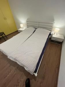 a large bed in a room with two night stands at Appartement entier dans chalet traditionnel in Bratsch