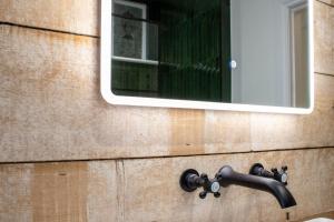 a mirror on the side of a building with a sink at Unique 1 Bed Apartment, Auchterarder in Auchterarder