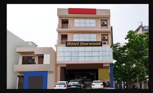 a building with cars parked in front of it at Hotel Starwood Near Airport Road Sector 78 Mohali Chandigarh in Mohali