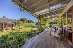 a wooden deck with a pergola at Wanaka Lakeside Serenity at Eely Point with Pool in Wanaka