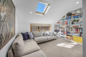a living room with a couch and book shelves at Wanaka Lakeside Serenity at Eely Point with Pool in Wanaka