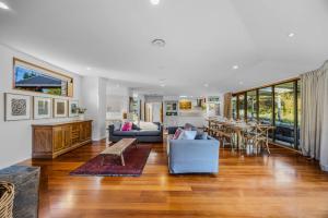a living room with a couch and a table at Wanaka Lakeside Serenity at Eely Point with Pool in Wanaka +58 photos