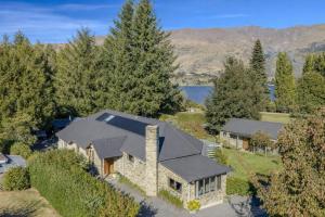 an aerial view of a home with a stone house at Wanaka Lakeside Serenity at Eely Point with Pool in Wanaka