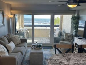 a living room with a couch and a view of the ocean at Ocean Front Condo-Beach Front Pool Hottub Elevator in Myrtle Beach
