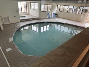 a large swimming pool with blue chairs in a building at Ocean Front Condo-Beach Front Pool Hottub Elevator in Myrtle Beach