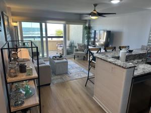 a kitchen and living room with a view of the ocean at Ocean Front Condo-Beach Front Pool Hottub Elevator in Myrtle Beach
