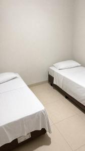 two beds sitting next to each other in a room at Apto Centro de Sinop - 720C in Sinop