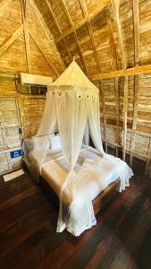 a bedroom with a bed with a canopy in a room at Rice Field and Mountain View House in Karangasem