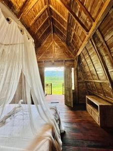 a bedroom with a bed with a mosquito net at Rice Field and Mountain View House in Karangasem