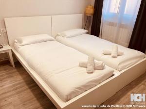 two beds in a room with white sheets and pillows at San Gregorio 2 in Soria