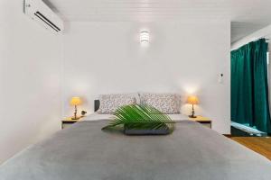 a large bed in a white room with two lamps at Modern Villa with Pool & Garden in Farehau