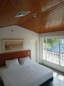 a bedroom with a bed with a wooden ceiling and a window at Hotel Cabaleón in Tena +26 photos