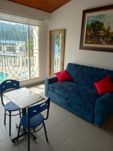 a living room with a blue couch and a table at Hotel Cabaleón in Tena