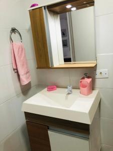 a bathroom with a white sink and a mirror at Casa com piscina in Londrina +9 photos