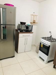 a kitchen with a stove and a refrigerator at Casa com piscina in Londrina
