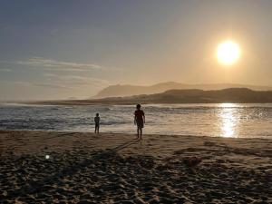 two people standing on the beach watching the sunset at Sand Castle in Sedgefield