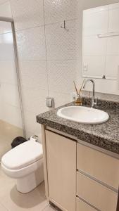 a bathroom with a white toilet and a sink at Apto Centro de Sinop - 720C in Sinop +8 photos