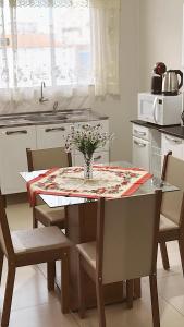 a kitchen with a table with a vase of flowers on it at Apto Centro de Sinop - 720C in Sinop