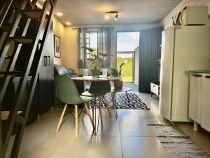a kitchen with a table and chairs and a refrigerator at Loft Confortável e Tranquilo - Fernandópolis in Fernandópolis