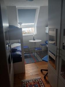 a small room with a bed and a table and a window at Landhotel Eisdorf in Eisdorf