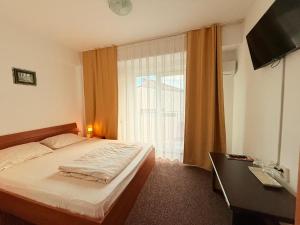 a bedroom with a bed and a large window at Vila Gymy in Constanţa
