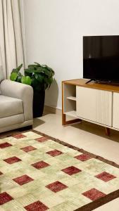 a living room with a television and a couch at Apto Centro de Sinop - 720C in Sinop