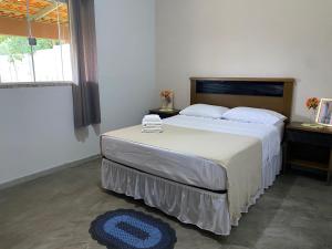 a bedroom with a bed and a large window at Chácara Por do Sol in Pouso Alegre +51 photos