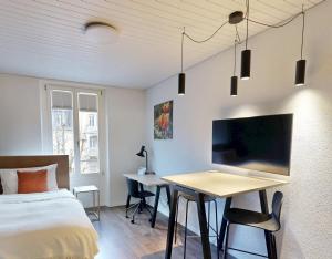 a bedroom with a bed and a desk with a bed and a table at Apartmenthouse Viktoria in Bern in Bern