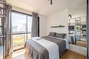 a bedroom with two beds and a balcony at Flipchave | Highline design in Joinville +61 photos