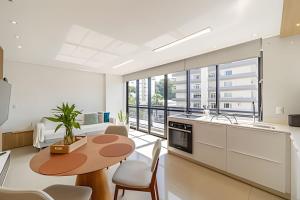 a kitchen and living room with a table and chairs at Flipchave | Highline design in Joinville