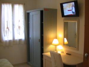 a bedroom with a dresser with a mirror and a television at Agriturismo Dolceacqua in Cavallino-Treporti
