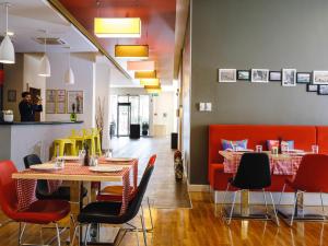 a restaurant with red chairs and tables and a table and chairsktop at Ibis Istanbul Esenyurt in Istanbul