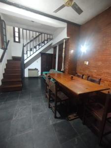 a dining room with a wooden table and a staircase at Casa Garú in Paso de los Libres +1 photo