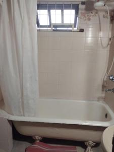 a bathroom with a tub and a window and a sink at Casa Garú in Paso de los Libres