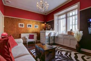 a living room with red walls and a couch and a table at Tiffanys Boutique - Coorie Doon Stays in Prestwick