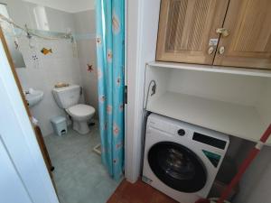 a bathroom with a washing machine and a toilet at Villa Ioanna in Agkidia