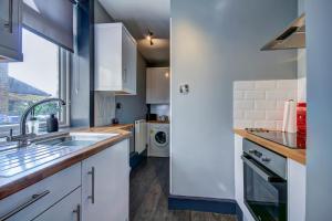 a kitchen with white cabinets and a sink at Tiffanys Boutique - Coorie Doon Stays in Prestwick +15 photos