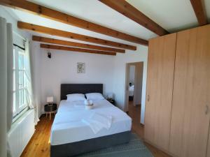 a bedroom with a white bed and a large window at Villa Ioanna in Agkidia