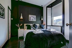 a bedroom with a bed with green walls and a window at Tiffanys Boutique - Coorie Doon Stays in Prestwick