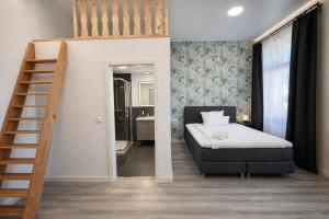 a small bedroom with a bed and a staircase at MIILOX Apartments Chemnitz Hainstrasse in Chemnitz