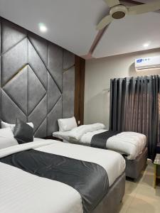 a room with three beds and a ceiling fan at Arizona 2 in Islamabad