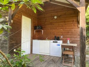 an outdoor kitchen with a stove and a table at Ti Bwa in Sainte-Luce